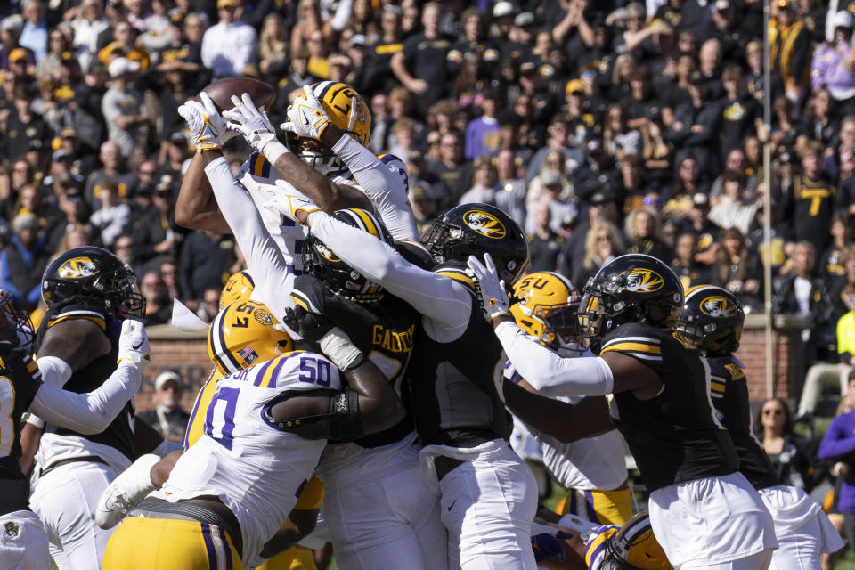 LSU running back Logan Diggs, top left, leaps over the Missouri defense to score a touchdown during the first quarter of an NCAA college football game Saturday, Oct. 7, 2023, in Columbia, Mo. (AP Photo/L.G. Patterson)