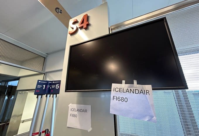 a photo of the S4 gate at Seattle-Tacoma airport with switched-off displays with a piece of paper taped to the screen, saying ICELANDAIR FI680.