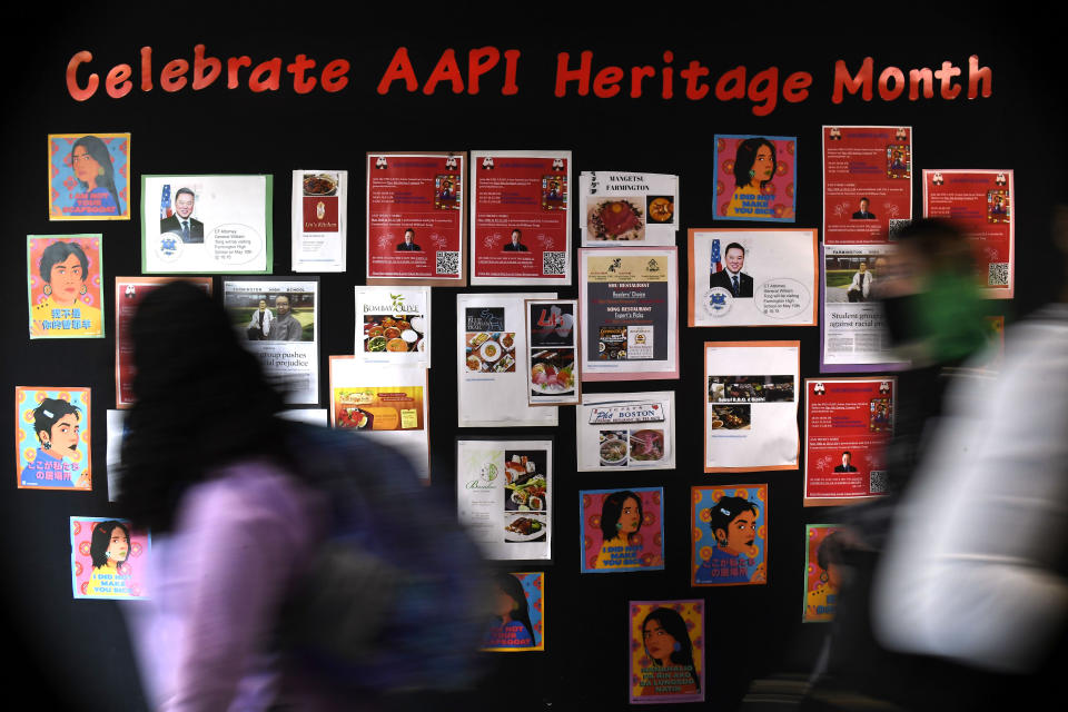 In this Monday, May 10, 2021 students walk past a display for Asian Pacific American Heritage Month at Farmington High School in Farmington, Conn. The year of anti-Asian violence has led students and teachers to advocate for reexamining how Asian American studies and history are taught in public schools. (AP Photo/Jessica Hill)