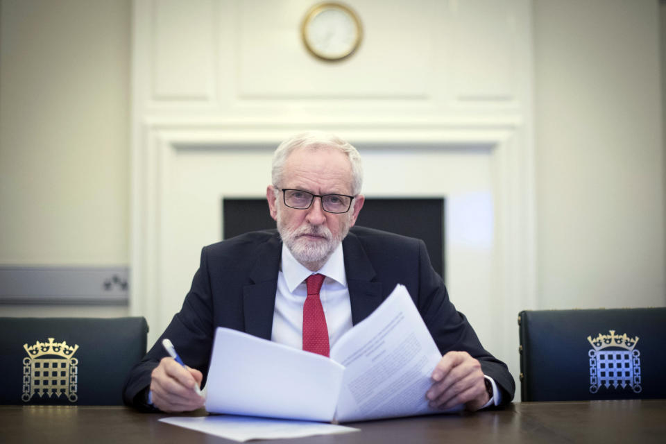 Britain's Labour leader Jeremy Corbyn poses for the media with the Political Declaration setting out the framework for the future UK-EU relationship, in his office in the Houses of Parliament in London, Tuesday, April 2, 2019. Opposition leader Corbyn says he is happy to sit down with Prime Minister Theresa May to work on a Brexit deal, even though "so far she hasn't shown much sign of compromise." The leader of the left-of-center Labour Party says "we recognize that she has made a move" and is willing to hold talks with May. (Stefan Rousseau/Pool Photo via AP)