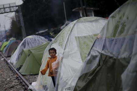 A child stands at the entrance of a tent at a makeshift camp for refugees and migrants at the Greek-Macedonian border, near the village of Idomeni, Greece March 15, 2016. REUTERS/Alkis Konstantinidis
