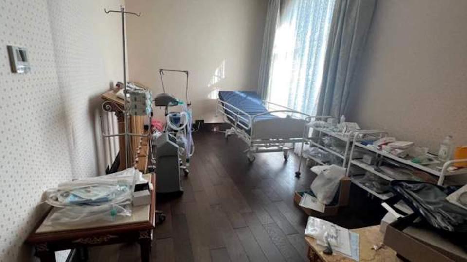 Medical equipment, including a bed, in a small white room
