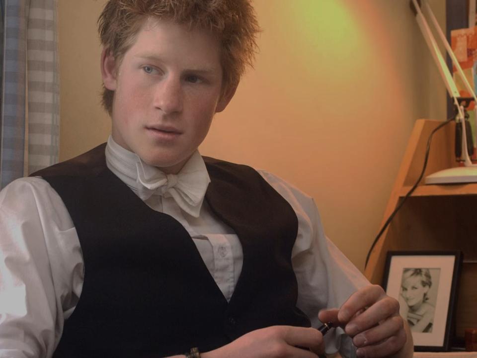 Prince Harry sits in front of a desk.