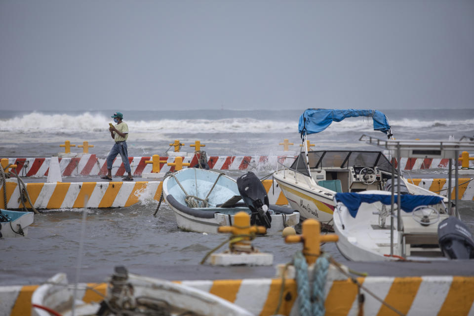 A fisherman talks on his phone in the Veracruz state of Mexico, Friday, Aug. 20, 2021. Residents began making preparations for the arrival of Tropical Storm Grace. (AP Photo/Felix Marquez)