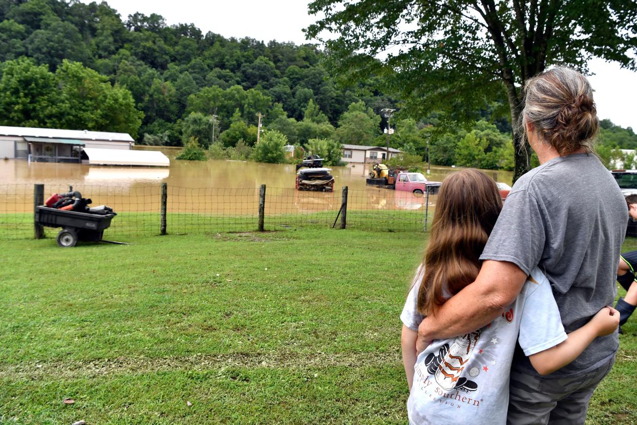 Bonnie Combs hugs her 10-year-old granddaughter Adelynn Bowling as the North Fork of the Kentucky River encroaches on her property in Jackson, Ky., on Thursday, July 28, 2022. 