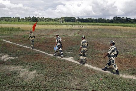 Indian Border Security Force (BSF) soldiers walk across the open border with Bangladesh to attend a flag meeting in West Bengal, June 20, 2015. REUTERS/Rupak De Chowdhuri