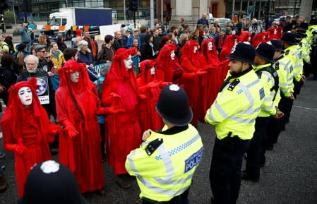 Activistas de la "La Brigada Roja" gesticulan en frente de la policía durante las manifestaciones de Extinction Rebellion contra el cambio climático en Londres