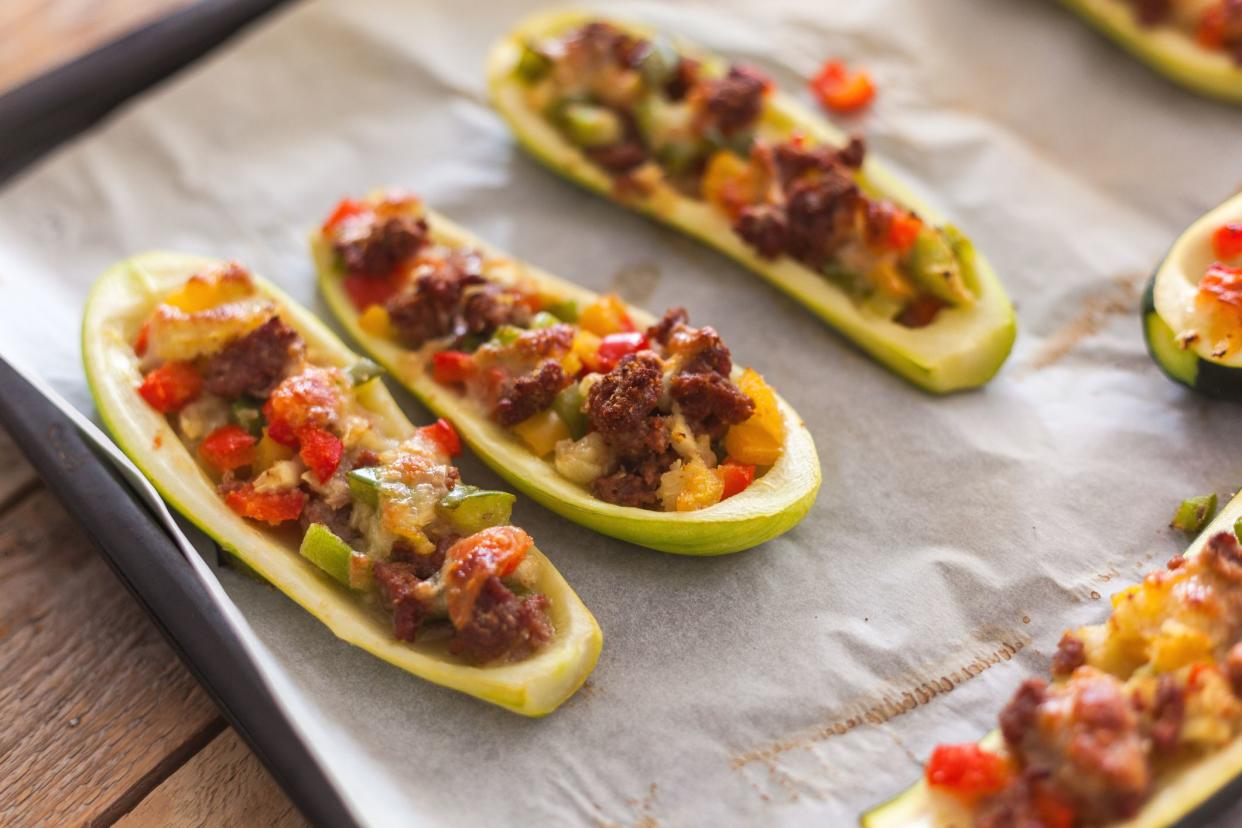 Zucchini stuffed with minced meat and vegetables, baked in oven, close-up