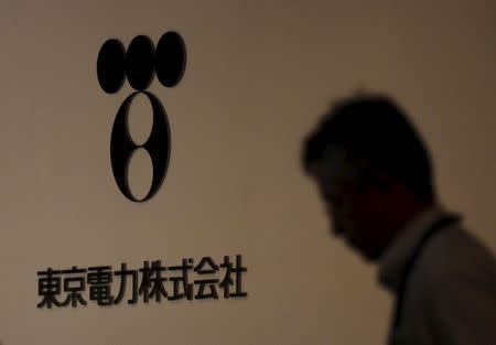 A man walks past Tokyo Electric Power Co (TEPCO)'s logo at the company headquarters in Tokyo in this July 30, 2012 file photo. REUTERS/Yuriko Nakao/Files