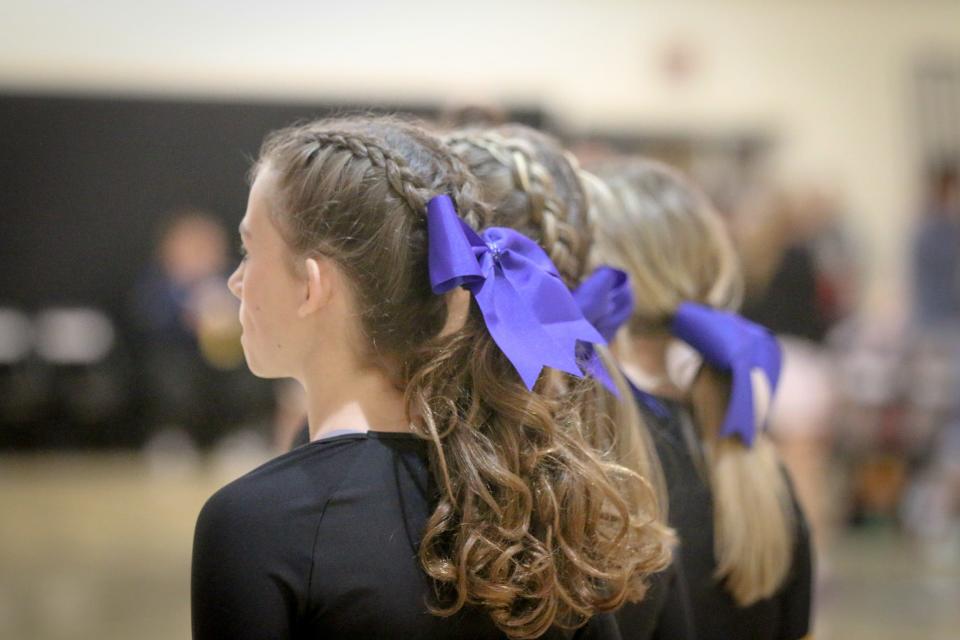 Cheerleaders wear blue ribbons in support of neighboring district Perry during a basketball game between ADM and Winterset on Friday, Jan. 5, 2024, in Adel.