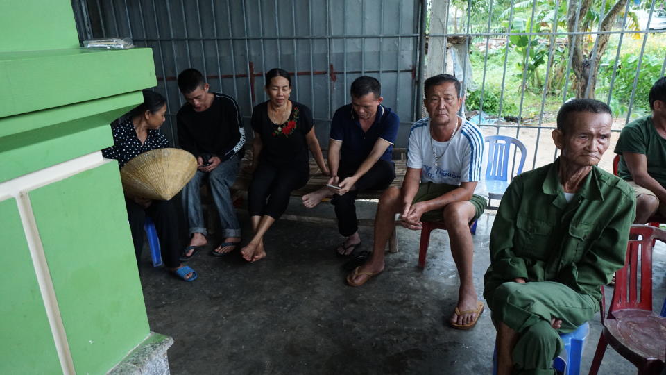 Relatives and neighbors of Bui Thi Nhung sit outside her family home in Do Thanh village in Vietnam, Saturday Oct. 26, 2019. Family members fear that Nhung could be among the dozens of people found dead in the back of a truck in southern England. (AP Photo/Linh Do)