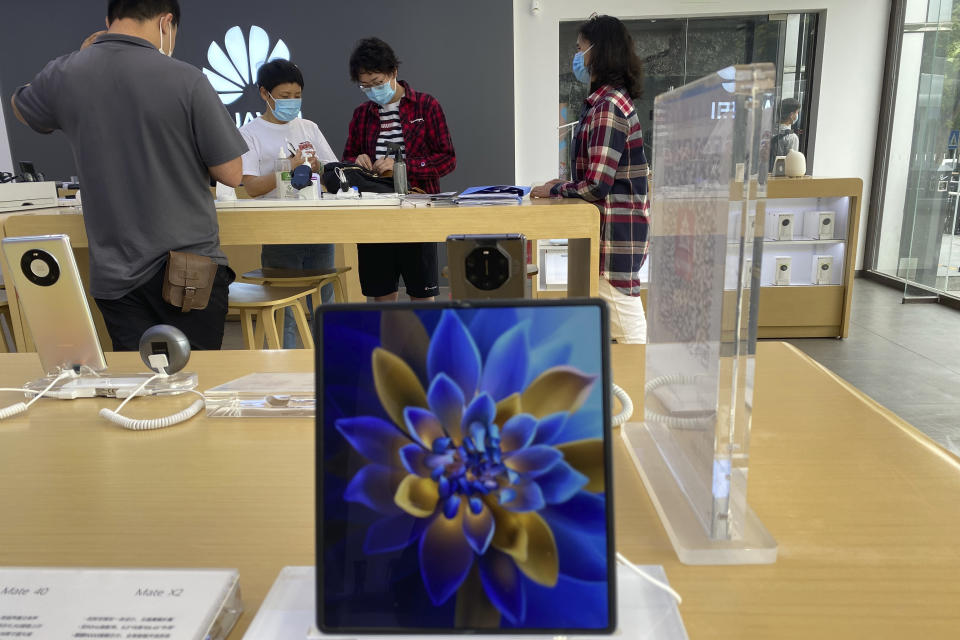 Customers visit a Huawei store in Beijing on Wednesday, June 2, 2021. Huawei is launching its own HarmonyOS mobile operating system on its handsets as it adapts to losing access to Google mobile services two years ago after the U.S. put the Chinese telecommunications company on a trade blacklist. (AP Photo/Ng Han Guan)