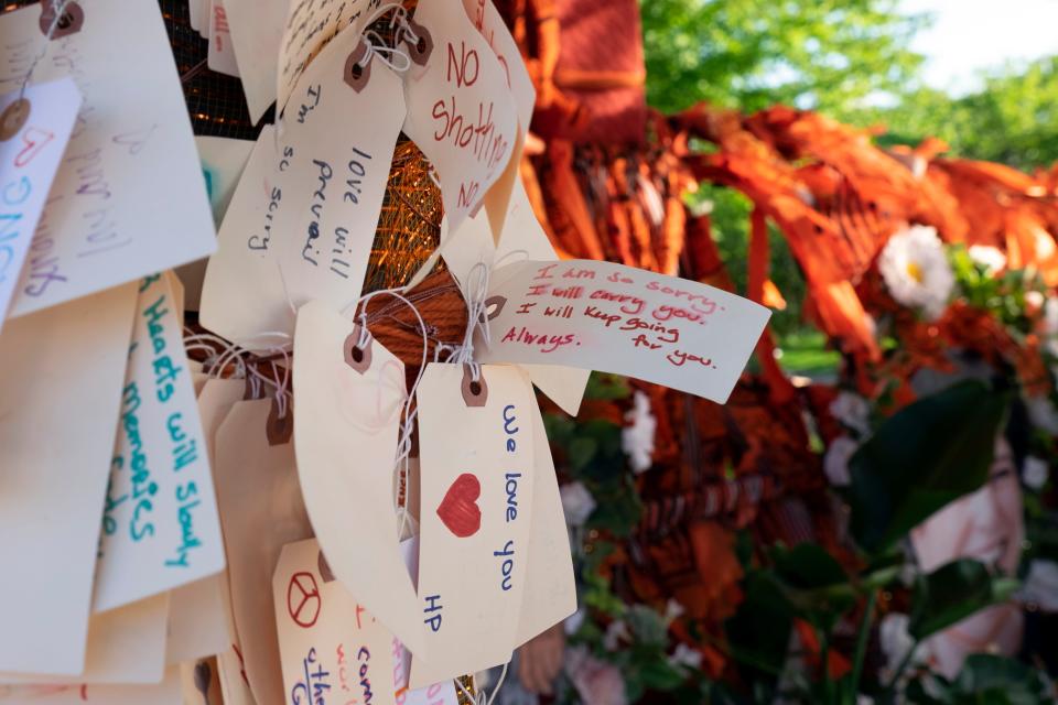 Handwritten notes on Aug. 2, 2022, cover a memorial for the victims of the mass shooting at a Fourth of July parade in downtown Highland Park, Ill.