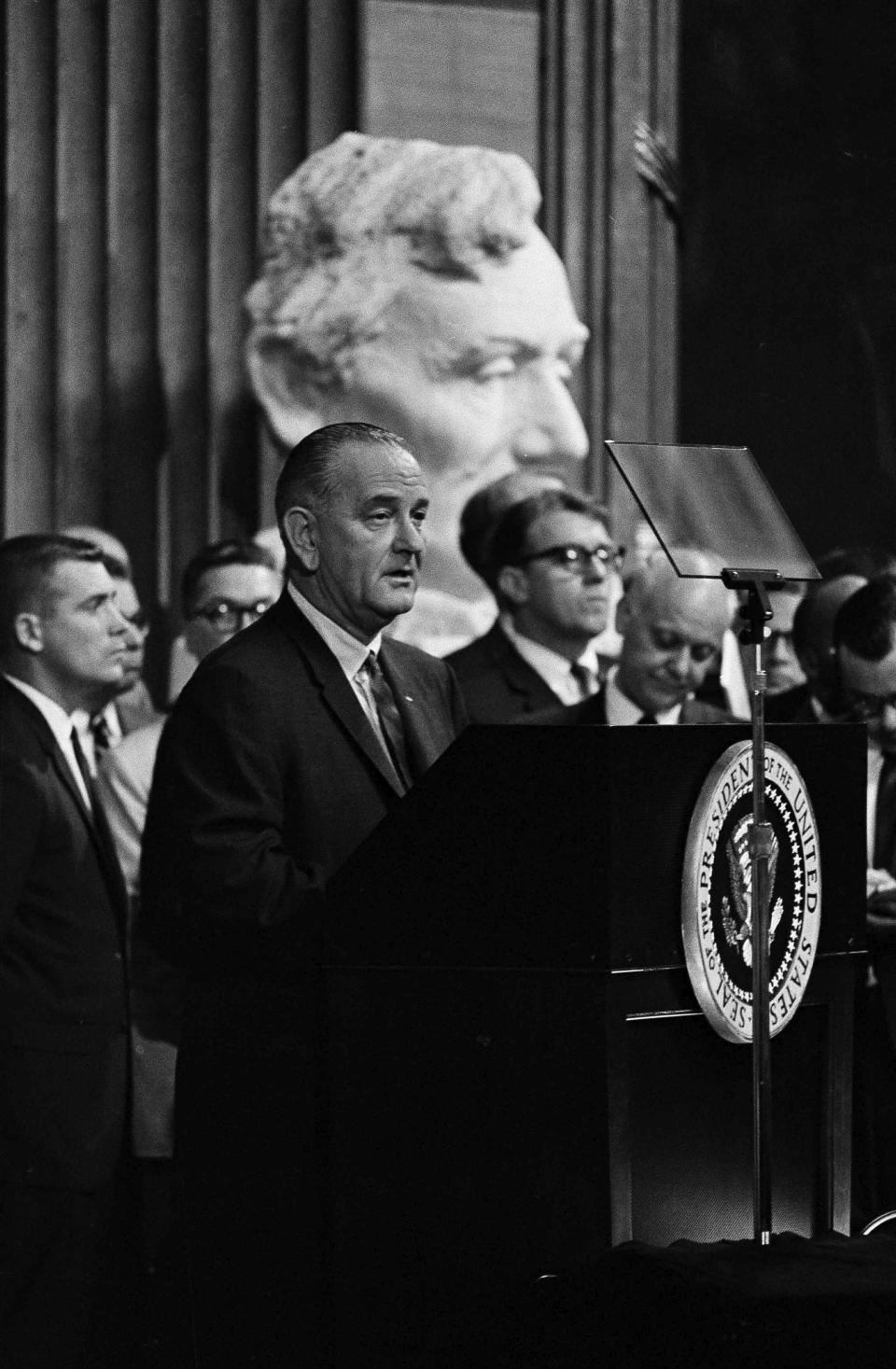 FILE - Against the backdrop of a statue of Abraham Lincoln, President Lyndon B. Johnson speaks in the Rotunda of the Capitol before signing the voting rights bill in Washington, on Aug. 6, 1965. (AP Photo)