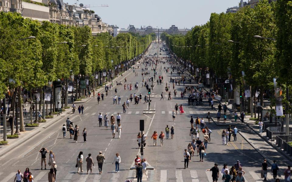 People walk in the middle of the Avenue Des Champs Elysees on pedestrianisation Sunday