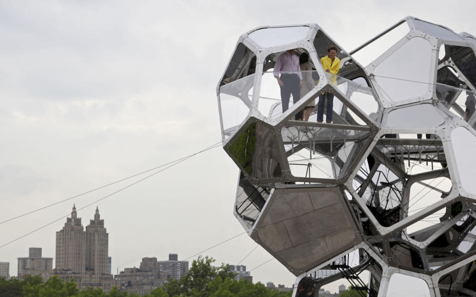 People visit a structure by Tomas Saraceno called "Cloud City" during a media preview on the rooftop of the Metropolitan Museum of Art in New York, Monday, May 14, 2012. The maker of Cloud City, Argentine artist Tomas Saraceno, wants to provoke the feeling of being in a cloud floating in the middle of several realities. (AP Photo/Seth Wenig)