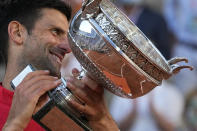 Serbia's Novak Djokovic smiles while holding the cup after defeating Stefanos Tsitsipas of Greece during their final match of the French Open tennis tournament at the Roland Garros stadium Sunday, June 13, 2021 in Paris. Djokovic won 6-7 (6), 2-6, 6-3, 6-2, 6-4. (AP Photo/Michel Euler)