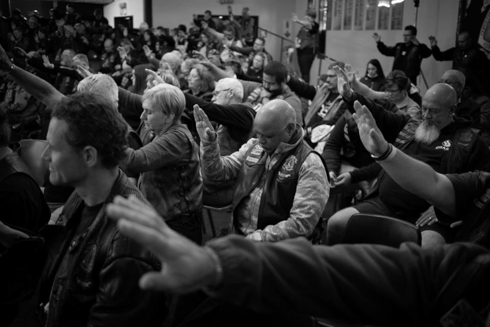 People raise their hands as they pray (EPA)