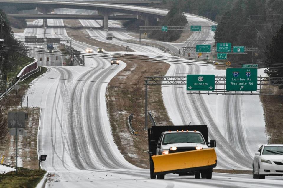 A truck with a snow plow attached makes its way eastbound on US 70 near the intersection with I-540 Sunday morning, January 16, 2022. A winter storm moving through the area dropped a combination of snow, sleet and freezing rain, making many roads and bridges slick.