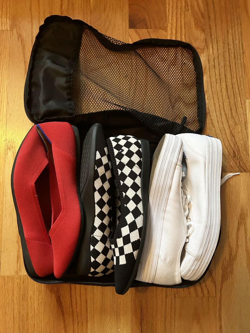 Mesh bag on floor with 3 pairs of shoes