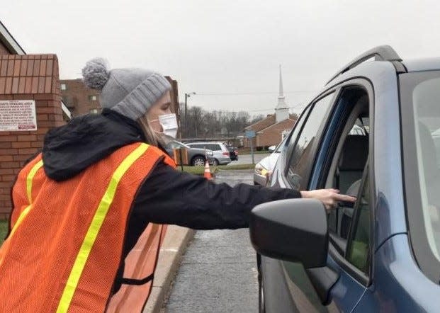 Audrey Sylvester, director of nursing for the Massillon Health Department, hands out a COVID-19 test kit Wednesday morning at the agency's parking lot. Overall, the Health Department passed out 294 kits in about 35 minutes.