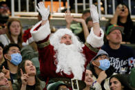 A fan dressed as Santa Claus cheers during the second half of an NBA basketball game between the Milwaukee Bucks and the Boston Celtics on Saturday, Dec. 25, 2021, in Milwaukee. The Bucks won 117-113. (AP Photo/Jon Durr)