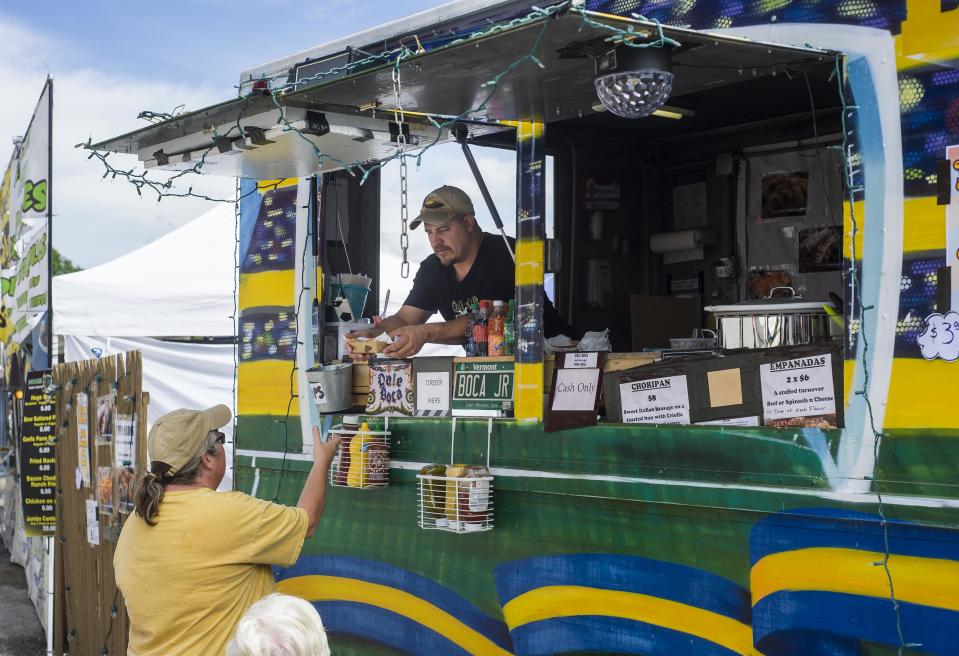 Javier Zirko of Grand Isle serves a customer some Argentinean cuisine from the Dale Boca food truck at the Champlain Valley Fair in Essex on Tuesday, August 29, 2017.