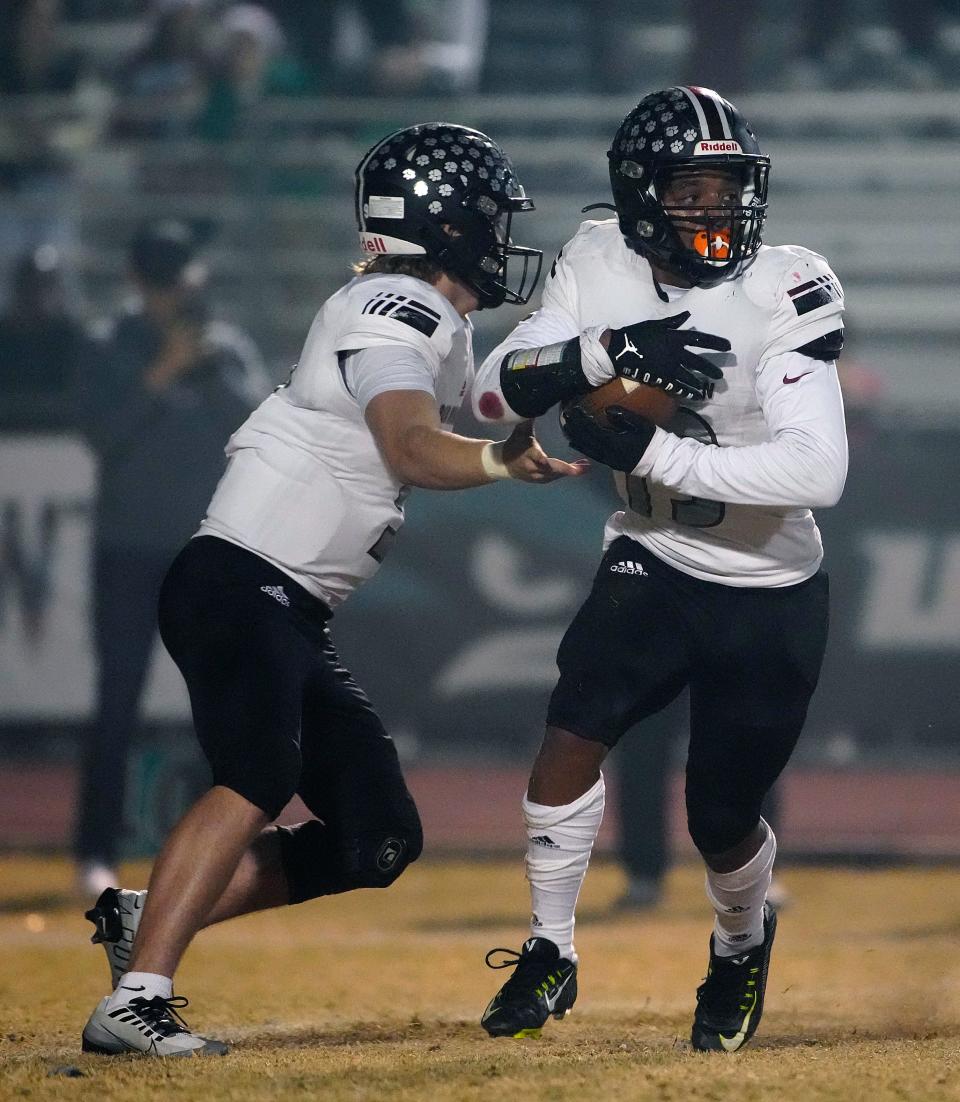 December 2, 2022; Gilbert, Ariz; USA; Red Mountain quarterback Carter Crispin (9) hands the ball off to runningback Lenox Lawson (13) during the 6A Semfinal at Highland High School.