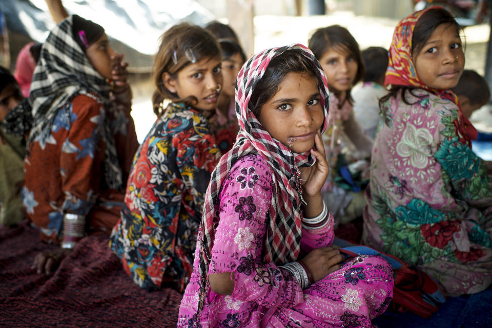 Children sit on the ground with a temporary roof to protect them against the strong sun in a small village called Bilwadi in the state of Rajasthan. The children who come from nomadic families are 6-14 years olds who are taught mathematics as well as reading and writing in Hindi. This photo was taken on October 29, 2014. 