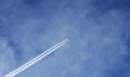 A helicopter is seen flying over the besieged town of Douma, Eastern Ghouta, Damascus, Syria February 20, 2018. REUTERS/Bassam Khabieh