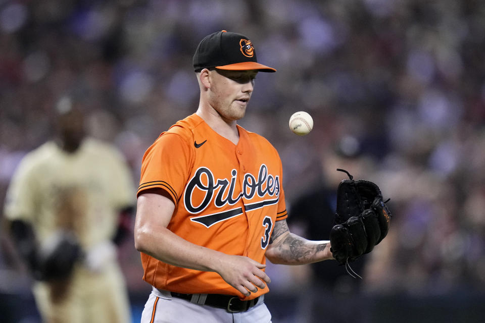 Baltimore Orioles starting pitcher Kyle Bradish flips the ball after allowing a hit to the Arizona Diamondbacks during the third inning of a baseball game Saturday, Sept. 2, 2023, in Phoenix. (AP Photo/Ross D. Franklin)