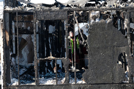 A fire investigator is seen at the house where seven children died from a fatal structure fire in the community of Spryfield in Halifax, Nova Scotia, Canada, on February 20, 2019. REUTERS/Ted Pritchard