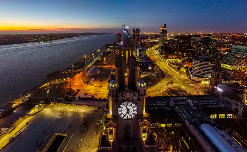 <p>The sun sets behind the Royal Liver Building in Liverpool. Picture date: Wednesday March 17, 2021.</p>
