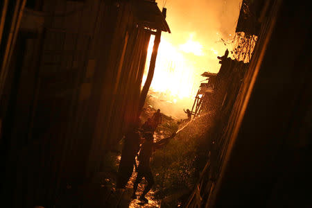 Residents are seen during a fire at Educando neighbourhood, a branch of the Rio Negro, a tributary to the Amazon river, in the city of Manaus, Brazil December 17, 2018. REUTERS/Bruno Kelly