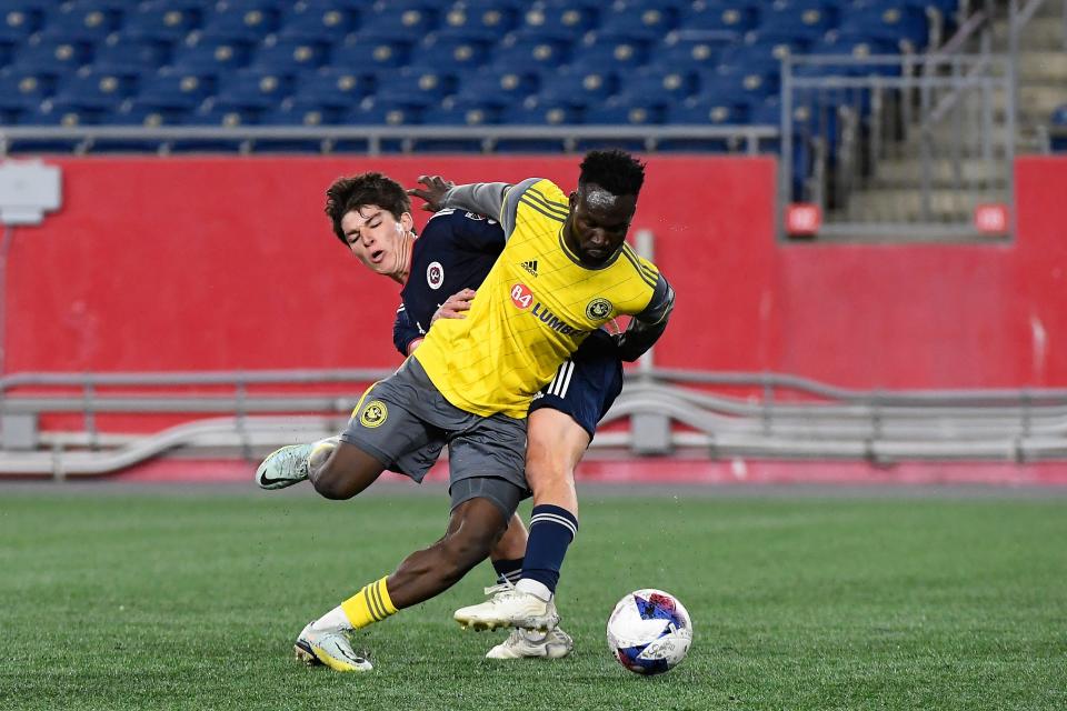 New England Revolution midfielder Jack Panayotou and then-Pittsburgh Riverhounds SC forward Albert Dikwa battle for the ball during a game in May at Gillette Stadium.