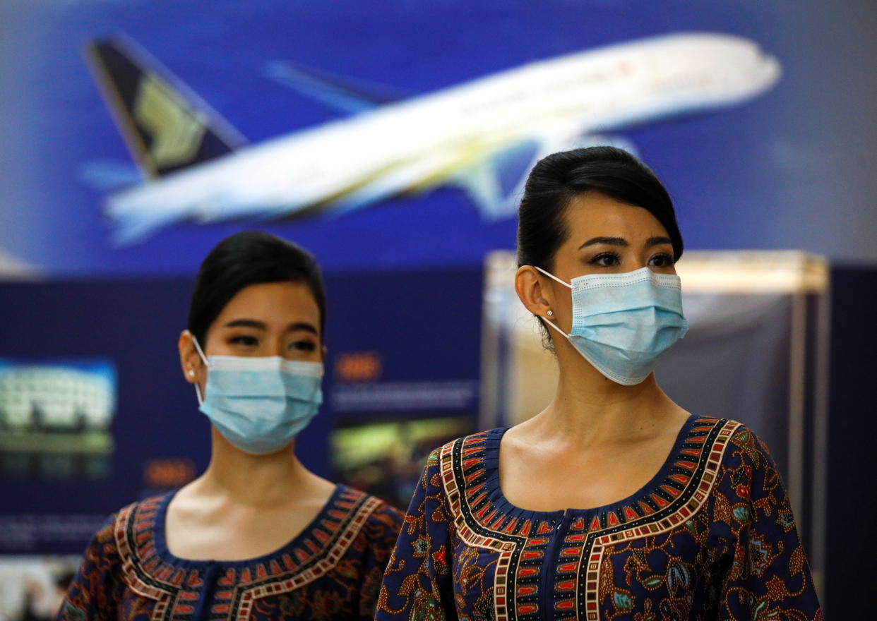 Cabin crew wait for participants during a guided tour at the Singapore Airlines Training Centre in Singapore November 21, 2020. The airlines offered tours of its training centre and flight simulator experiences as part of a series of initiatives to try an re-engage customers who have not been able to travel due to the coronavirus disease (COVID-19) pandemic.  REUTERS/Edgar Su