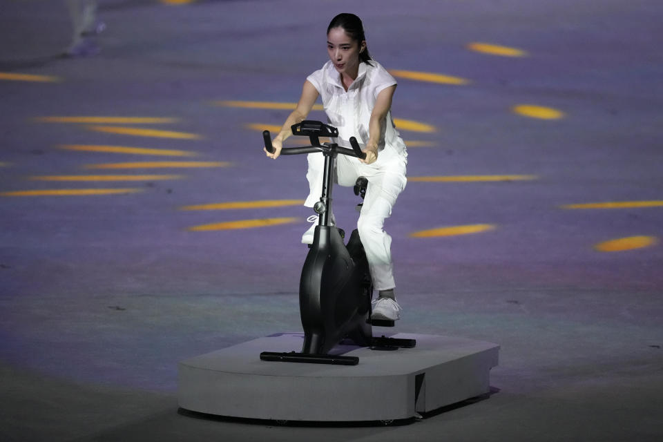 <p>A performer cycles during the opening ceremony in the Olympic Stadium at the 2020 Summer Olympics. (AP Photo/Ashley Landis)</p> 