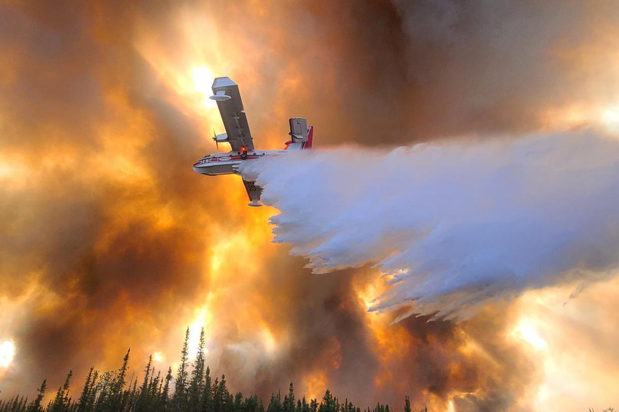 A fixed-wing aircraft drops water on the Clear Fire near Anderson, Alaska, on July 6, 2022. (Eric Kiehn, Northwest Incident Management Team 10, Alaska Division of Forestry via AP)