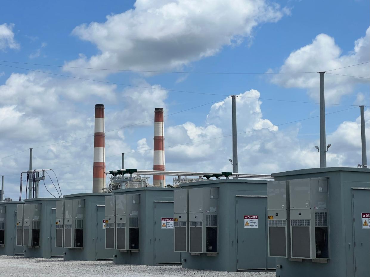 PAST PRESENT AND FUTURE: Two holdover 20th century smokestacks at Florida Power & Light's natural gas power plant in Parrish tower over the utility's new, 21st Century solar-powered battery storage facility.