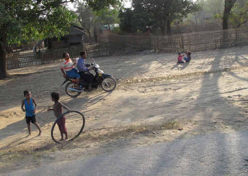 In this Feb. 26, 2014 photo, Rohingya children play along a road in The' Chaung village, Rakhine state, Myanmar. Thousands of Muslims from the persecuted ethnic minority were forced to flee to this dusty patch of land after sectarian violence erupted nearly two years ago when Buddhist mobs burned their homes. The segregated group faces health issues because they cannot easily access care at hospitals outside their encampment area. (AP Photo/Margie Mason)