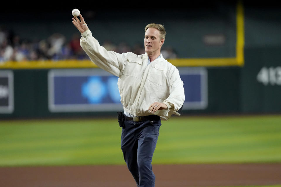 Bee keeper Matt Hilton throws out the ceremonial first pitch prior to a baseball game between the Los Angeles Dodgers and the Arizona Diamondbacks, Tuesday, April 30, 2024, in Phoenix. Hilton removed a swarm of bees on the net behind home plate that delayed the start of the game. (AP Photo/Matt York)