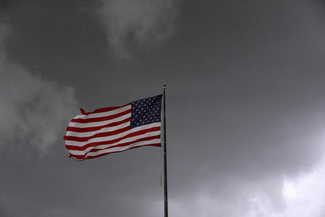 Storm clouds loom over an American flag in Convent, Louisiana, U.S., June 11, 2018. Picture taken June 11, 2018. REUTERS/Jonathan Bachman