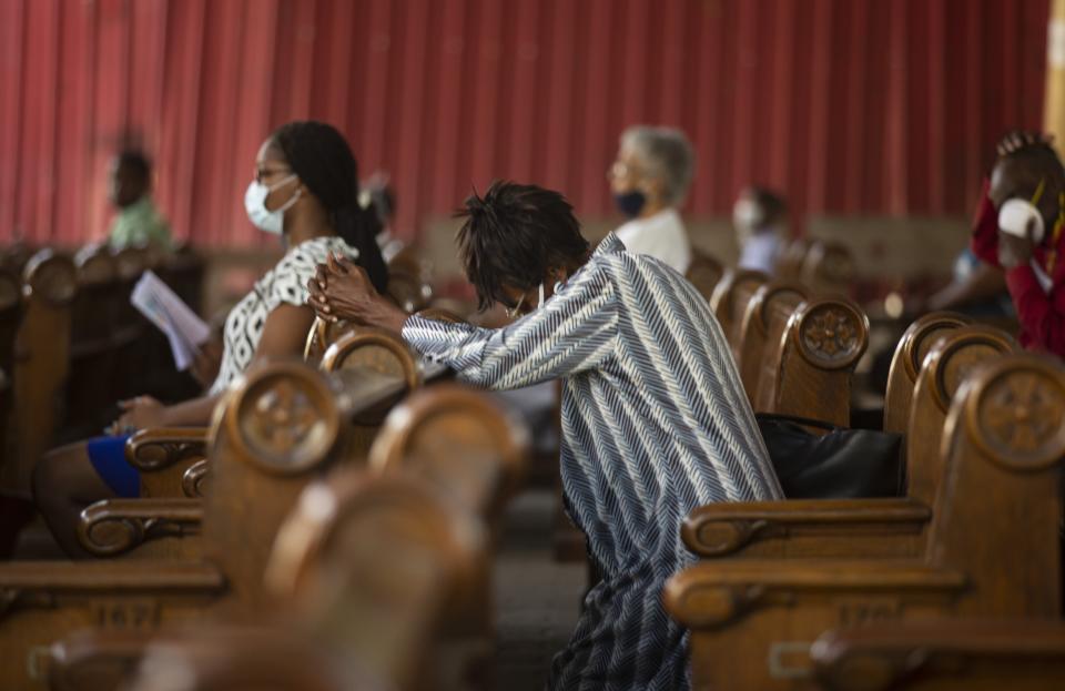 A woman prays during Sunday Mass at Sacre-Coeur church, in Port-au-Prince, Sunday, July 11, 2021, four days after President Jovenel Moise was assassinated in his home. (AP Photo/Joseph Odelyn)
