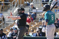 Home plate umpire Paul Clemons, left, calls a pitching clock violation against Chicago White Sox relief pitcher Reynaldo Lopez as Seattle Mariners' AJ Pollock (8) looks on during the third inning of a spring training baseball game Monday, Feb. 27, 2023, in Phoenix. (AP Photo/Ross D. Franklin)