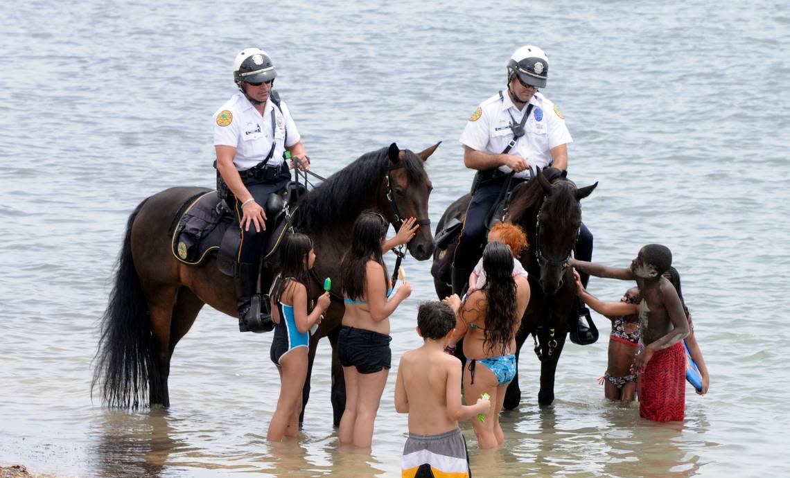 City of Miami Police Officer Eduardo Perez and his horse Striker, left, and Officer David Cruz with his horse Major, patrol Virginia Key beach and picnic area on 4th of July weekend in 2011.