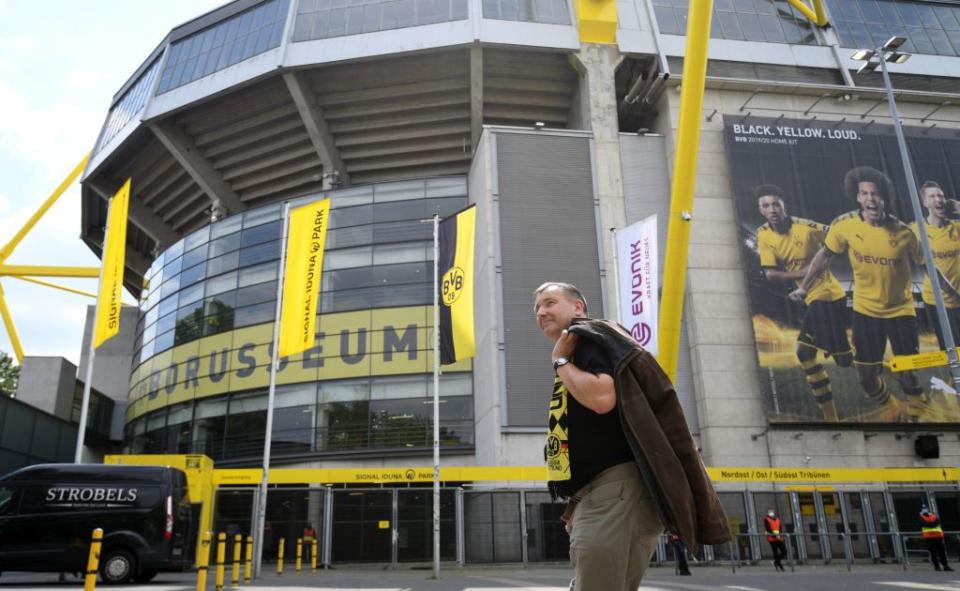 A supporter of Dortmund walks past the Signal Iduna Park before the German first division Bundesliga football match BVB Borussia Dortmund v Schalke 04 on May 16, 2020 in Dortmund, western Germany as the season resumed following a two-month absence due to the novel coronavirus COVID-19 pandemic. (Photo by INA FASSBENDER / AFP) (Photo by INA FASSBENDER/AFP via Getty Images)