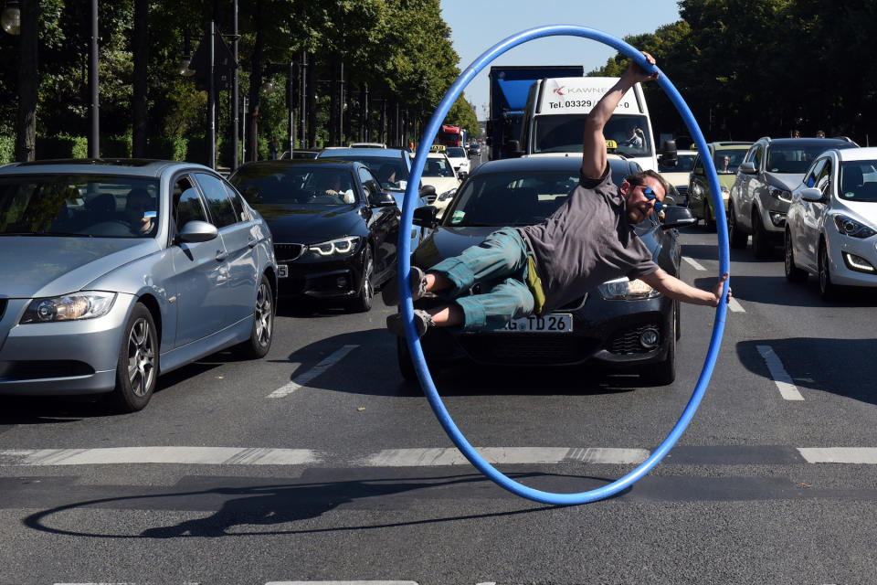 <p>Auf dem Großen Stern in Berlin verkürzt ein chilenischer Straßenkünstler den wartenden Autofahrern vor einer Ampel die Zeit. (Bild: Maurizio Gambarini/dpa) </p>