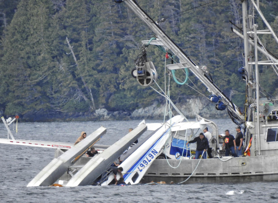 This Monday, May 20, 2019 photo provided by Aerial Leask shows good Samaritans off of fishing vessels attempting to bring in a floatplane that crashed in the harbor of Metlakatla, Alaska. Authorities say a pilot and a single passenger have died after the small plane crashed Monday near Ketchikan. (Aerial Leask via AP)