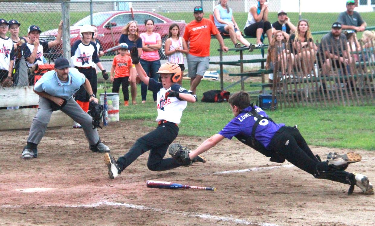 Quincy's Joe Gray slides in just past the tag of Bronson catcher Bryce Lundstrom Monday during the Branch County 4-H Fair Youth baseball tournament.