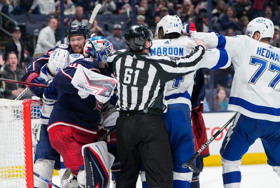 Columbus Blue Jackets goaltender Elvis Merzlikins (90) gets into a scuffle with Tampa Bay Lightning left wing Pat Maroon (14) and right wing Corey Perry (10) at the end of the second period of the NHL game at Nationwide Arena in Columbus on April 28, 2022.